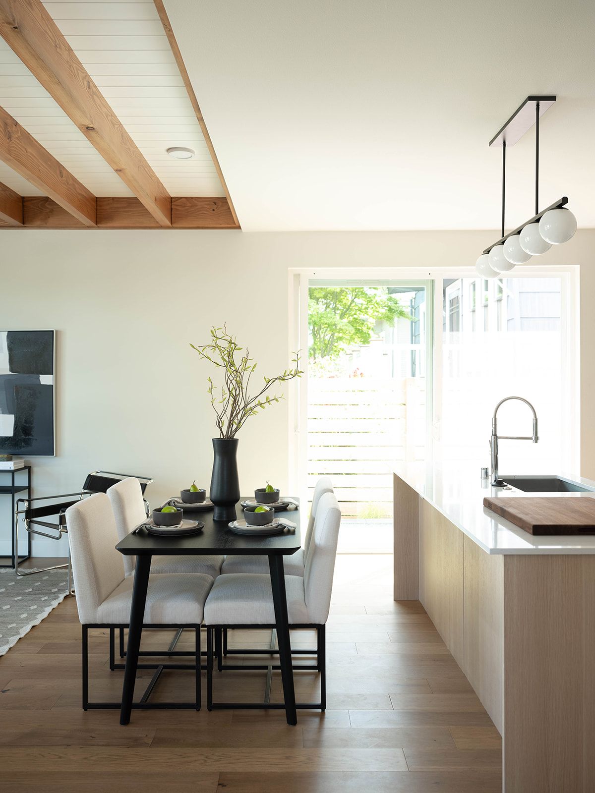 Dining area and kitchen under exposed wood beams, Three Queens