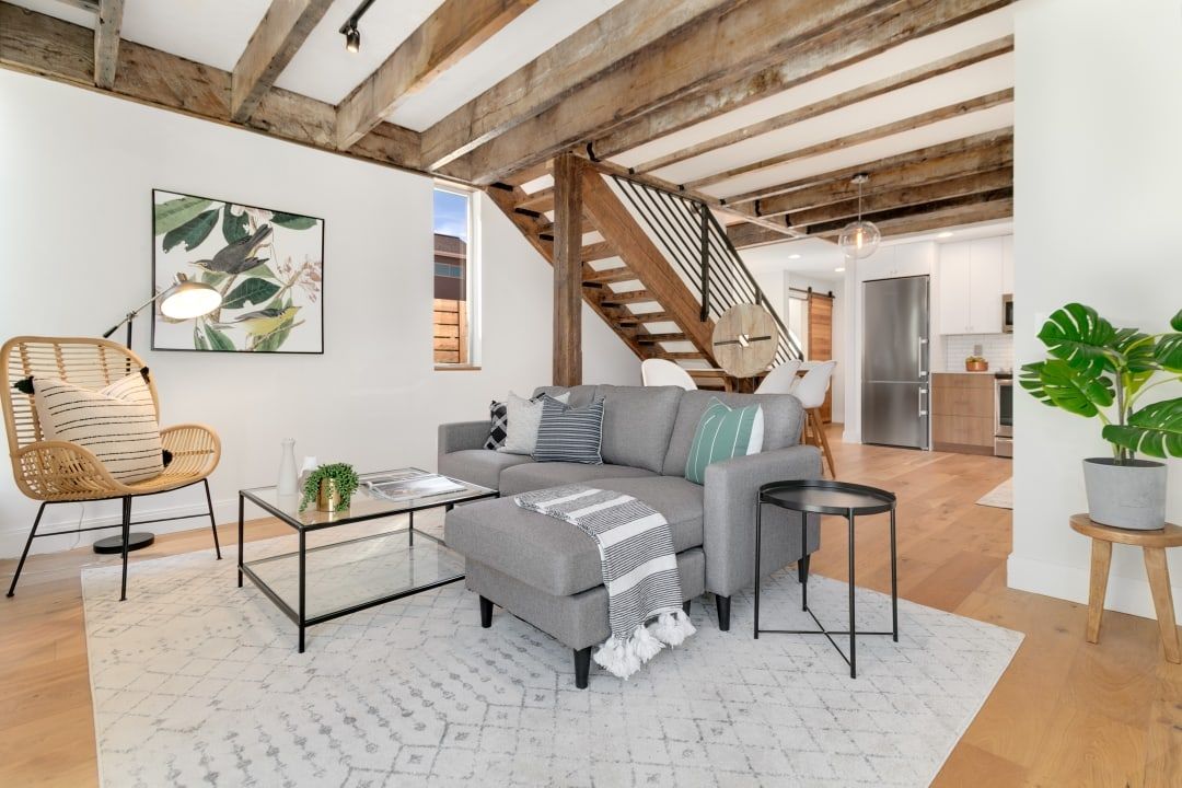 Living room with exposed beams and open stair