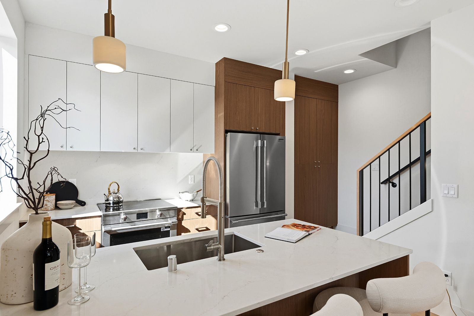 Kitchen with walnut and white cabinets and a quartz island